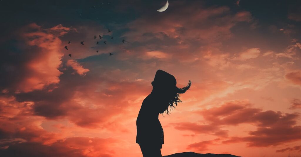 A silhouetted person under a crescent moon at twilight, evoking tranquil and peaceful vibes.