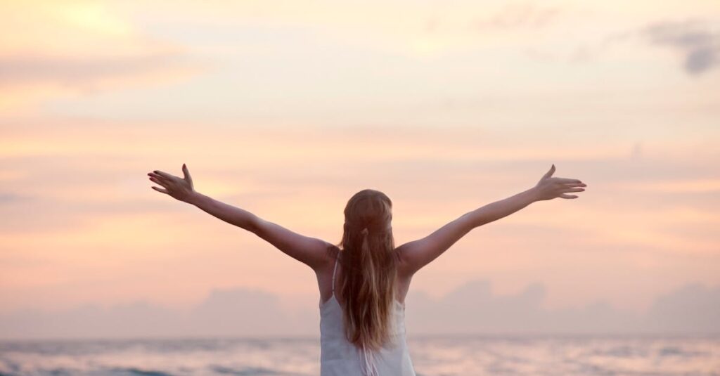 A woman enjoying a serene sunset on Unawatuna Beach, Sri Lanka, depicting peace and freedom.
