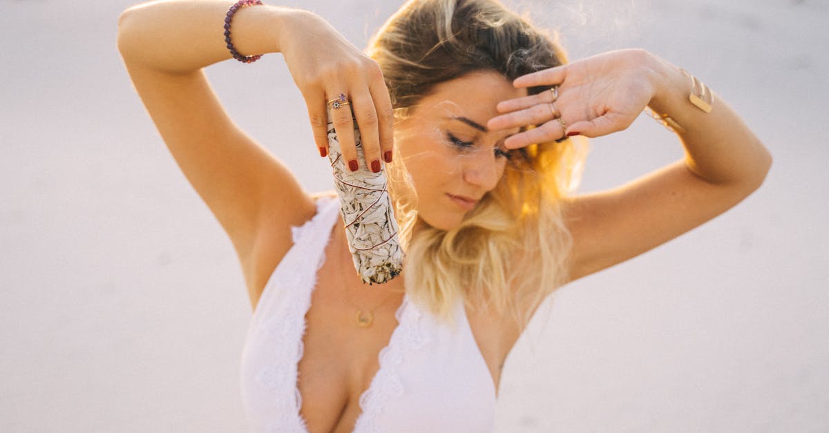 A serene woman practicing sage smudging outdoors for calming and purification.